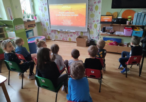 Dzieci oglądają film edukacyjny o dinozaurach
